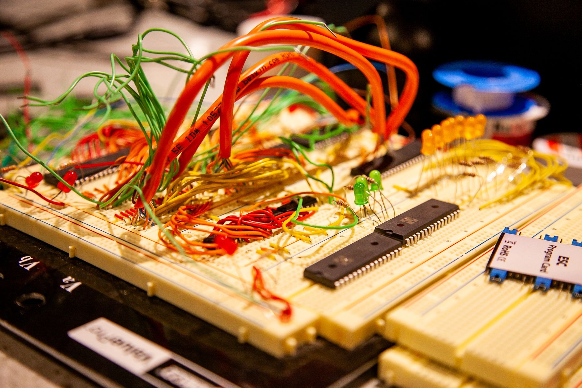 Breadboard with colored jumper wires, small LEDs and black chips, photographed at an angle