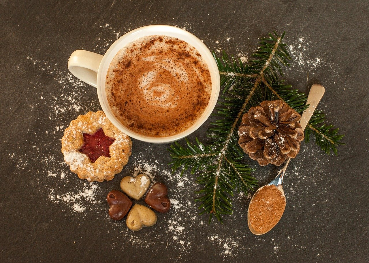 Several smooth, pale dough balls dusted with flour on a floured surface, with a wooden rolling pin in the background