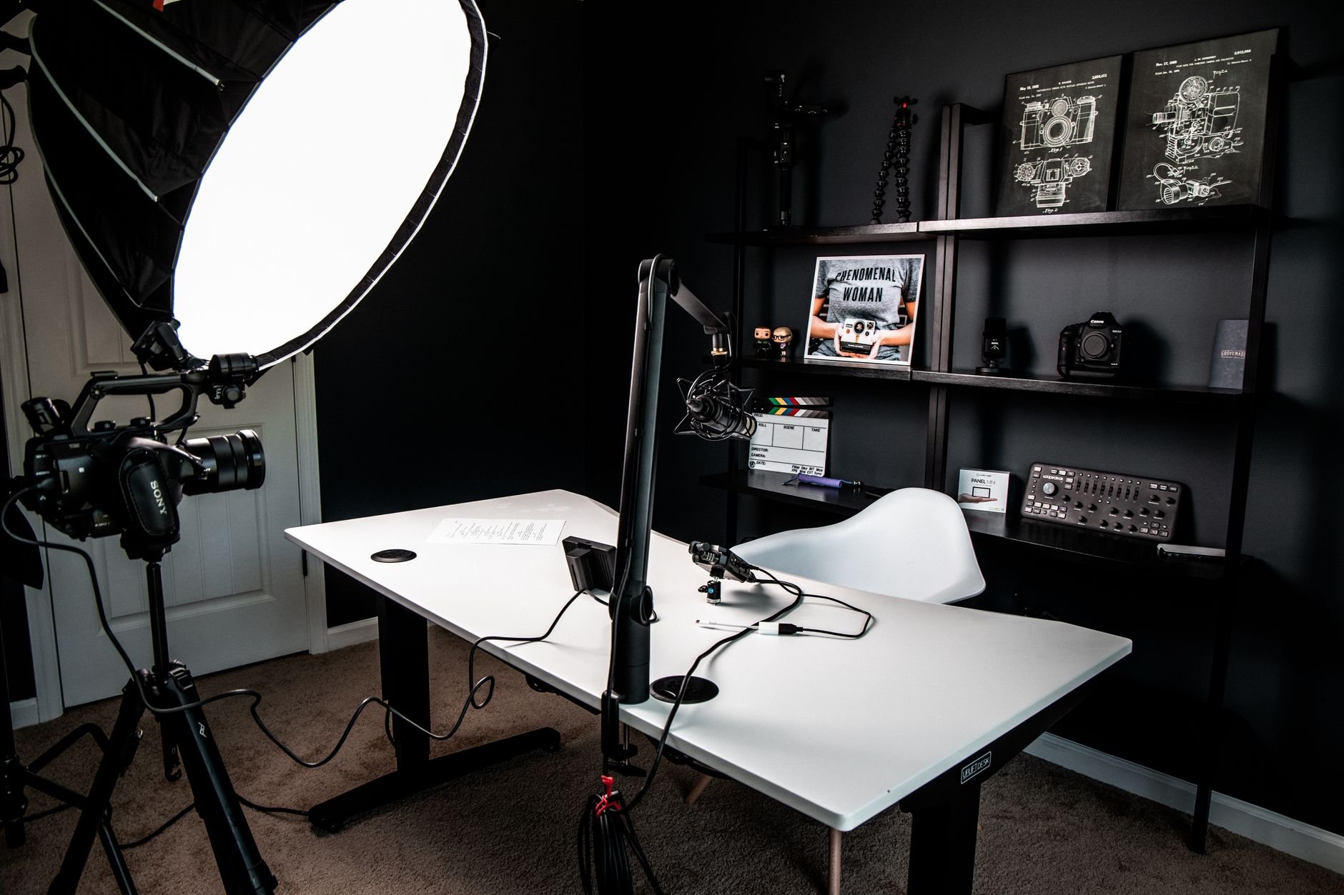 Home studio desk with a microphone arm, softbox light and camera on a tripod