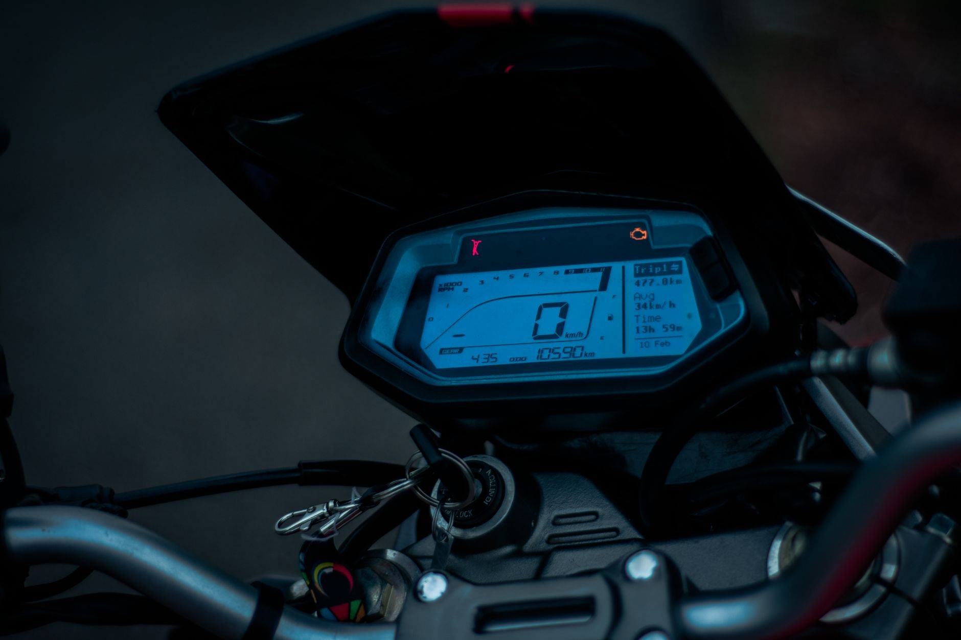 Motorcycle instrument cluster with a backlit digital display and a numeric readout, viewed from the handlebar area