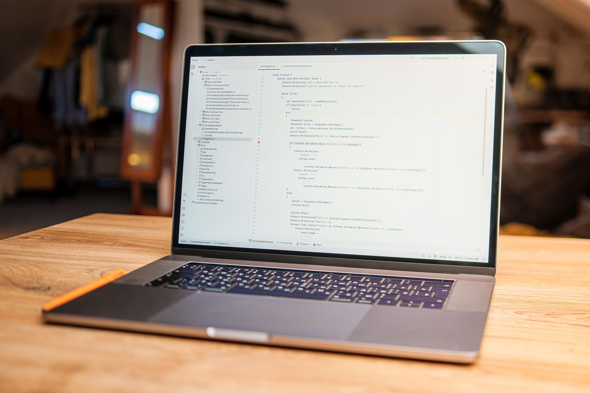 Open laptop on a wooden table displaying a code editor with a file tree and lines of code